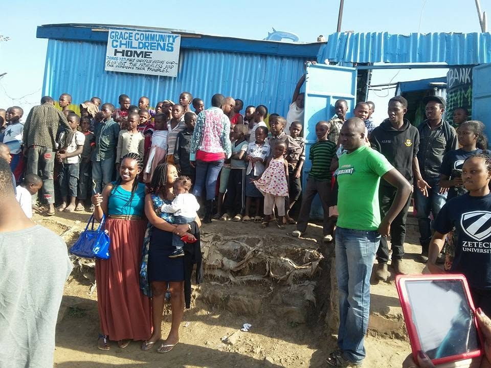 Children gathered outside The Grace Community Centre beneath its sign